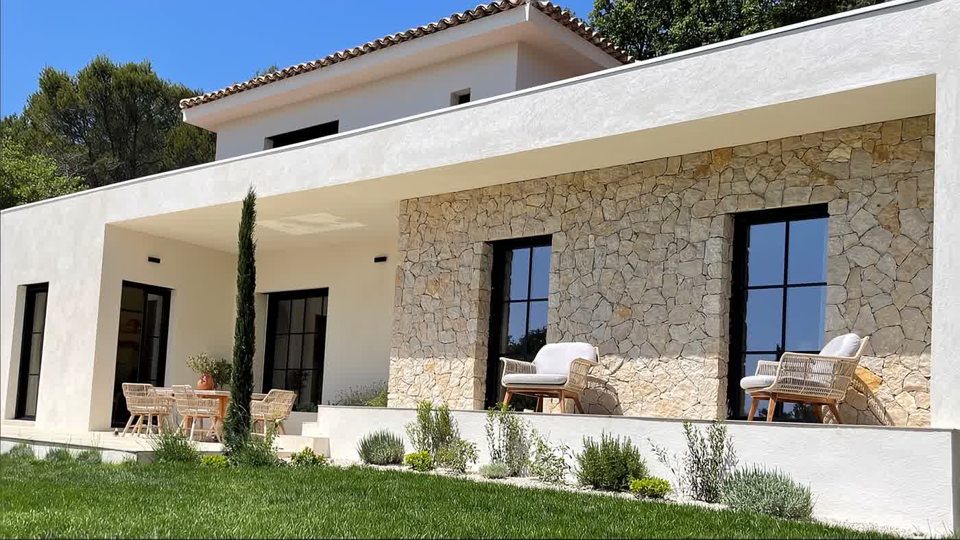 Façade d'une villa en pierre de parement opus combraille, la caméra s'approche du mur