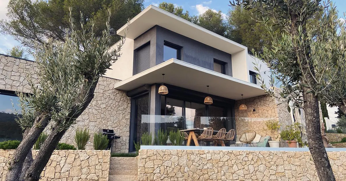 Villa contemporaine aux murs de soutènement en opus blond, entourée d'oliviers